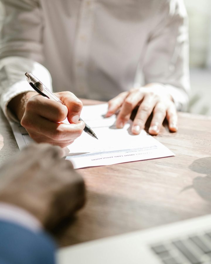 A consultant and a client reviewing documents at a desk